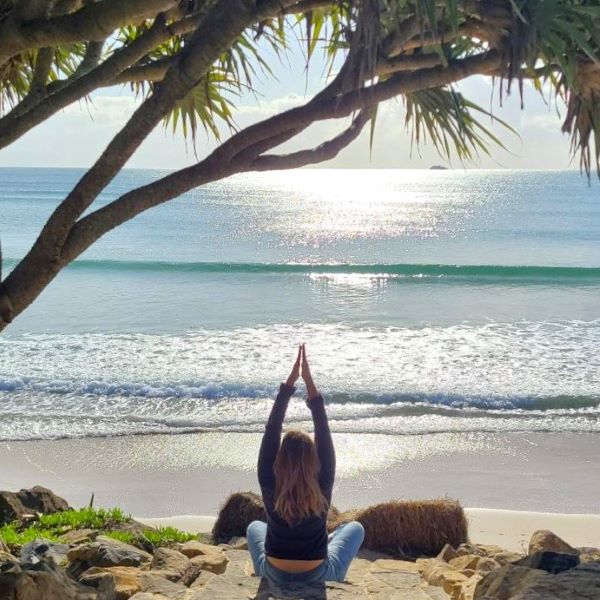Woman doing yoga on the beach